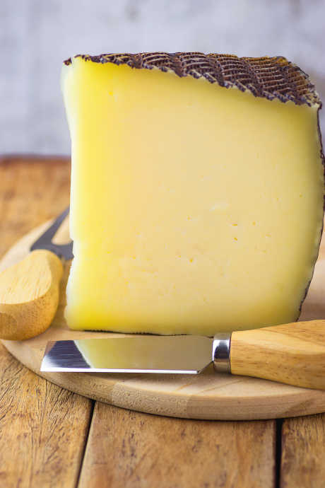 Manchego is a sheep’s milk cheese from the La Mancha region of Spain. It has a firm texture with an inedible waxed rind.