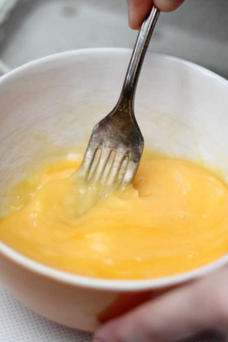 Once your eggs are room temperature at minimum, crack and mix them. You don’t need a whisk; in fact, most chefs prefer a fork. A fork will mix the white and yolk effectively.