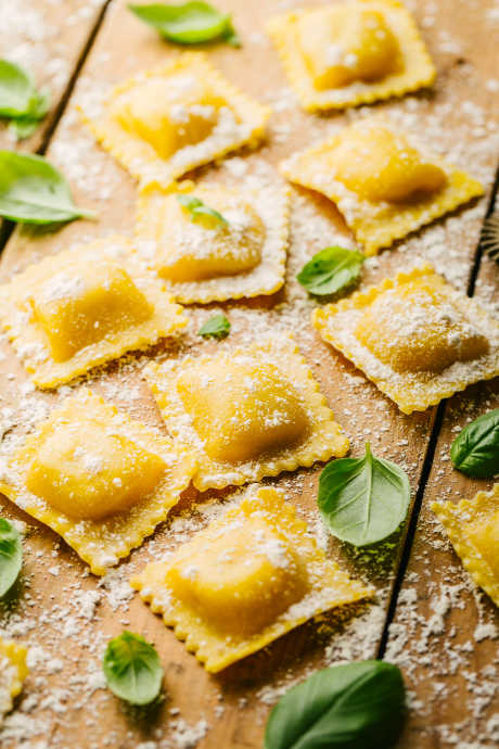 Ravioli looks like a tiny pillow, either square or circular, with filling in the middle.